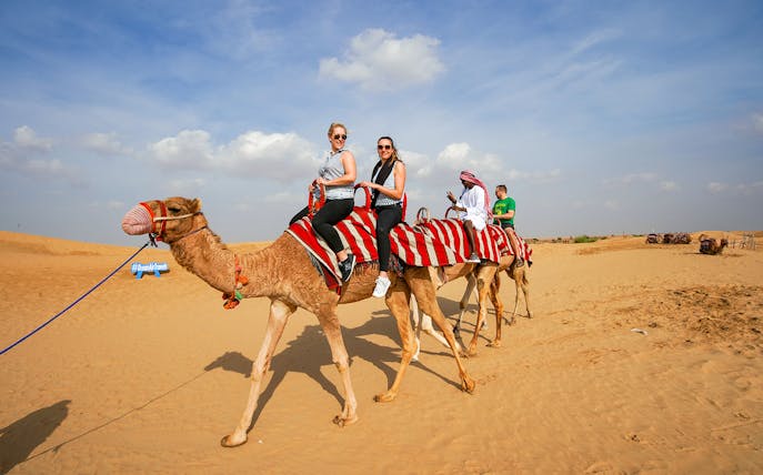 Camel ride in desert during 45 mins red dune bashing tour with sandboarding and BBQ.