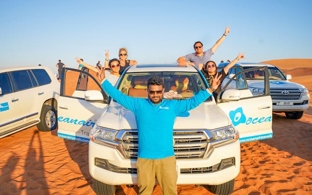 Group enjoying desert tour with 4x4 vehicles, part of 50 Min Quad Biking, Camel Ride & Sandboarding experience.