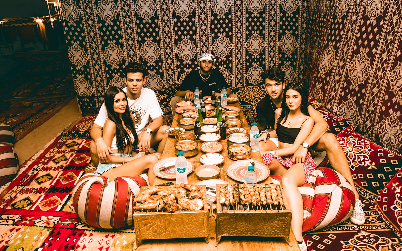 Group enjoying traditional meal at Al Marmoon Oasis Bedouin Camp, Dubai.