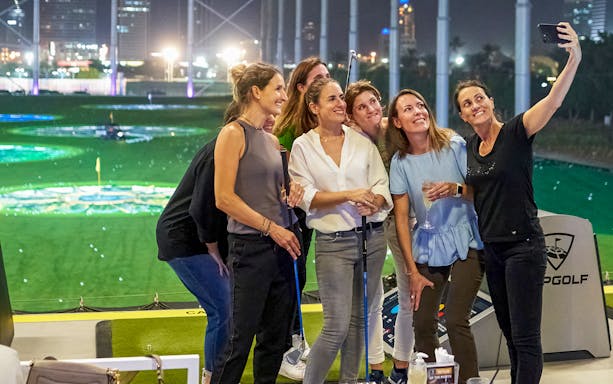 Group enjoying a night out at a golf entertainment venue during a Hop-On Hop-Off Tour.