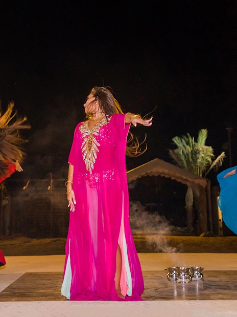 Dancers performing traditional Bedouin dance during desert safari night experience.
