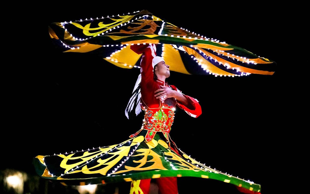Bedouin dancer performing traditional Tanoura dance during desert safari.