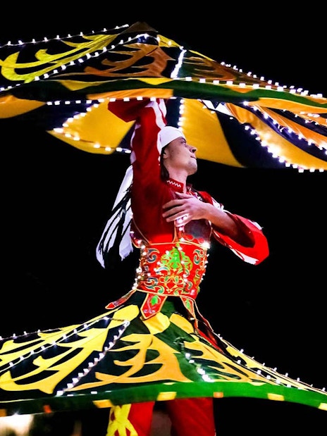 Bedouin dancer performing traditional Tanoura dance during desert safari.