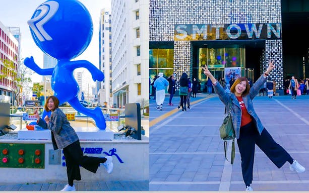 Person posing with blue Running Man statue and SMTOWN building in background.