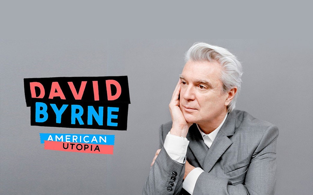 David Byrne in a suit next to "American Utopia" text.