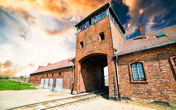 Auschwitz Birkenau entrance gate with railway tracks, part of Krakow day tour.