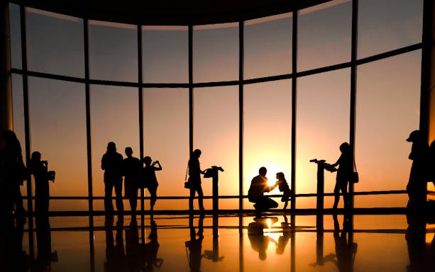 Visitors enjoying sunset views from Burj Khalifa observation deck in Dubai.