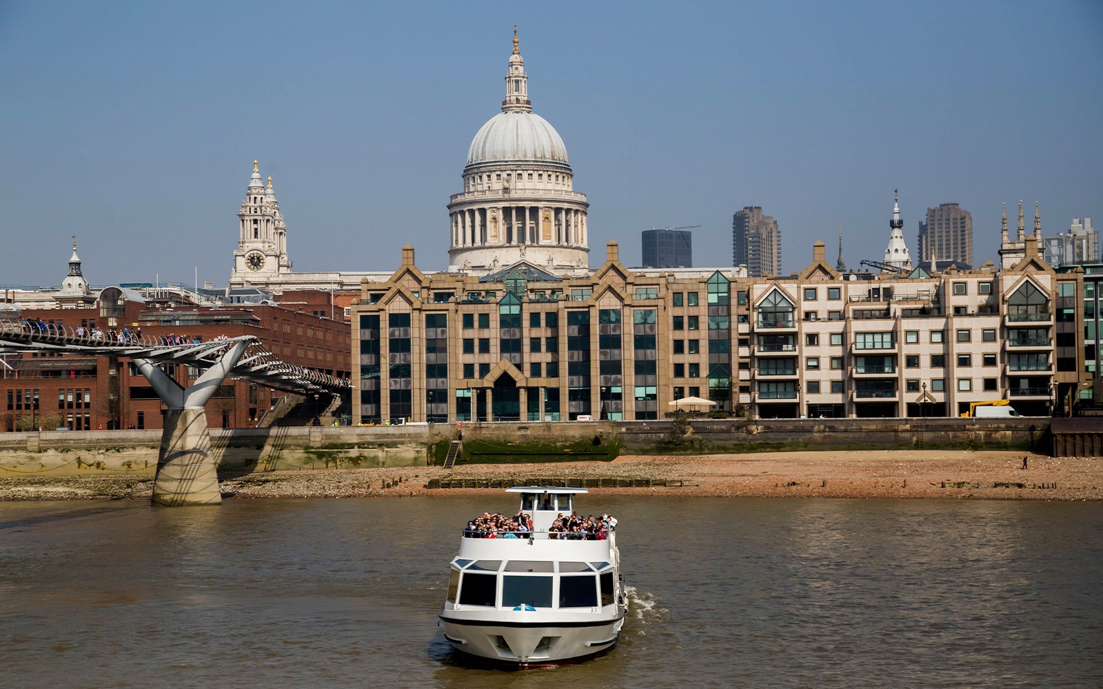 Passengers enjoying the Westminster to Tower of London Sightseeing Circular Cruise on River Thames with view of iconic London skyline