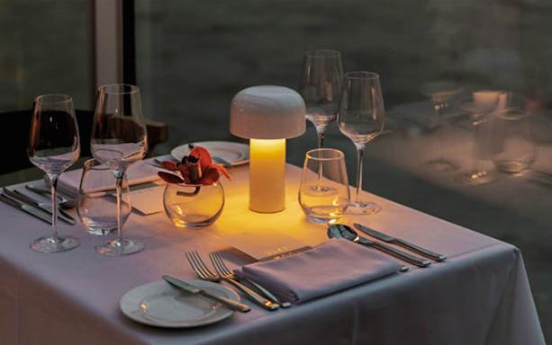 Elegant table setting on Bateaux London dinner cruise with ambient lighting.