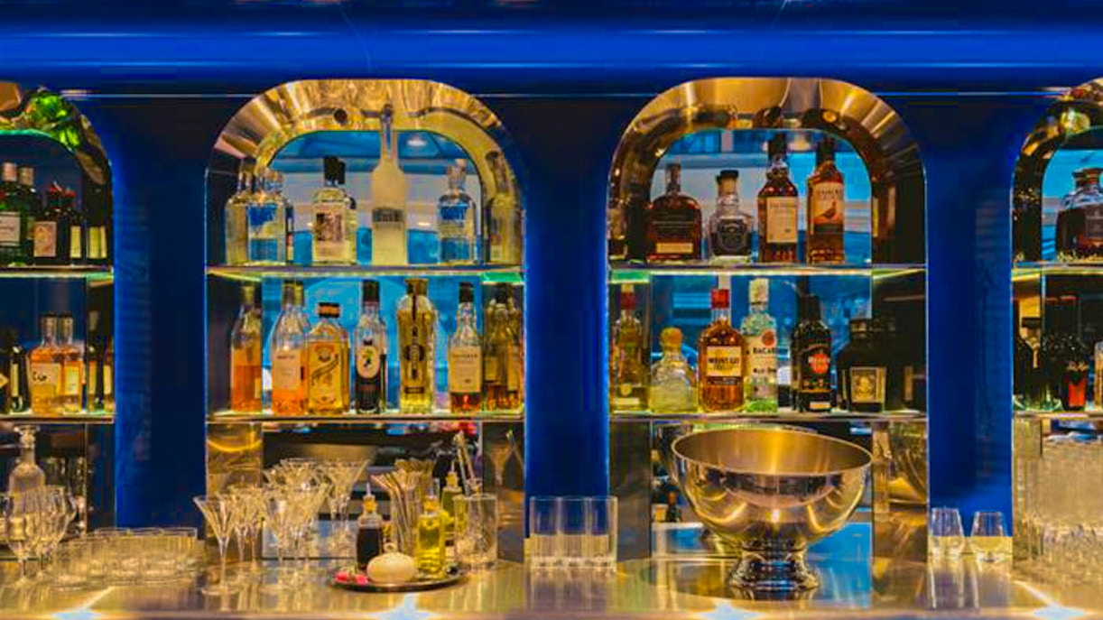 Bar with assorted bottles and glasses on Bateaux London dinner cruise on Thames.