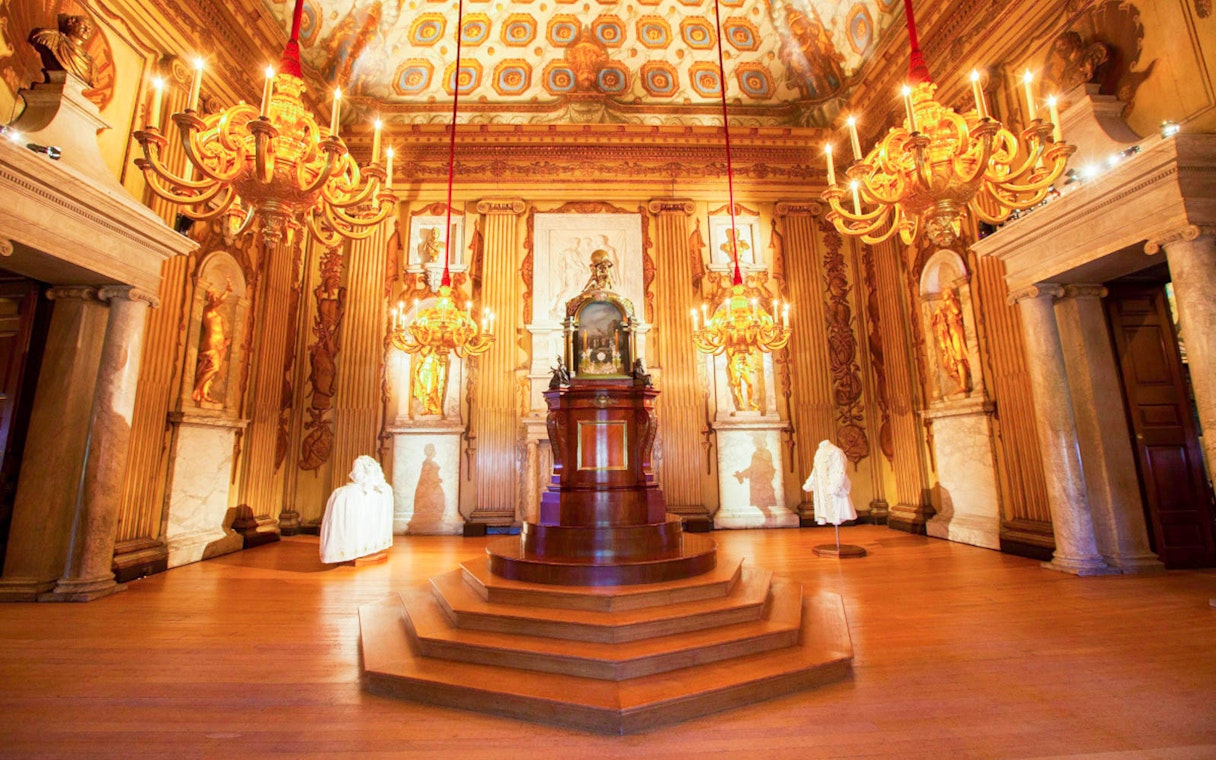 Kensington Palace ornate room with chandeliers and statues, London.