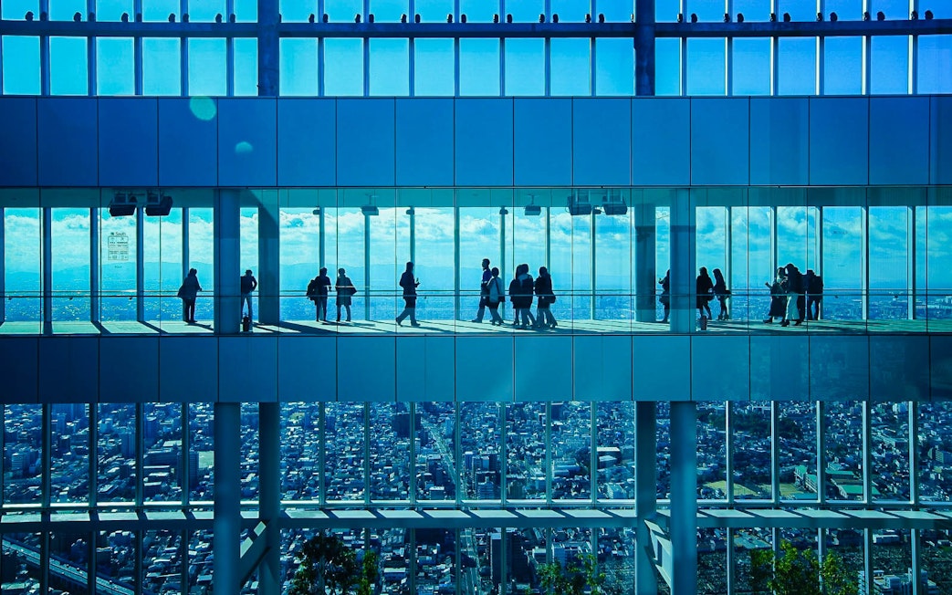Visitors at HARUKAS 300 Observatory with Osaka skyline view.