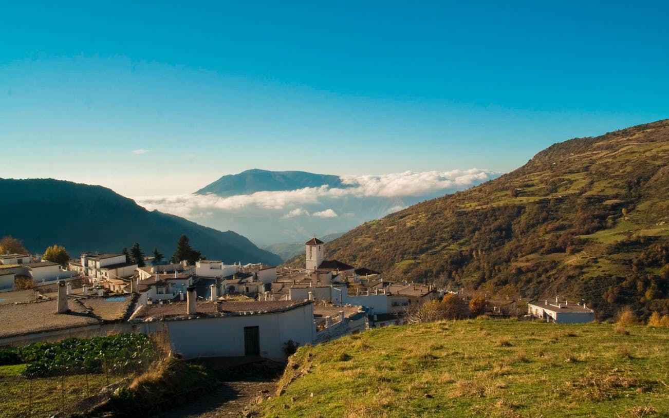 White village in Alpujarras with mountain backdrop on a day trip from Granada.