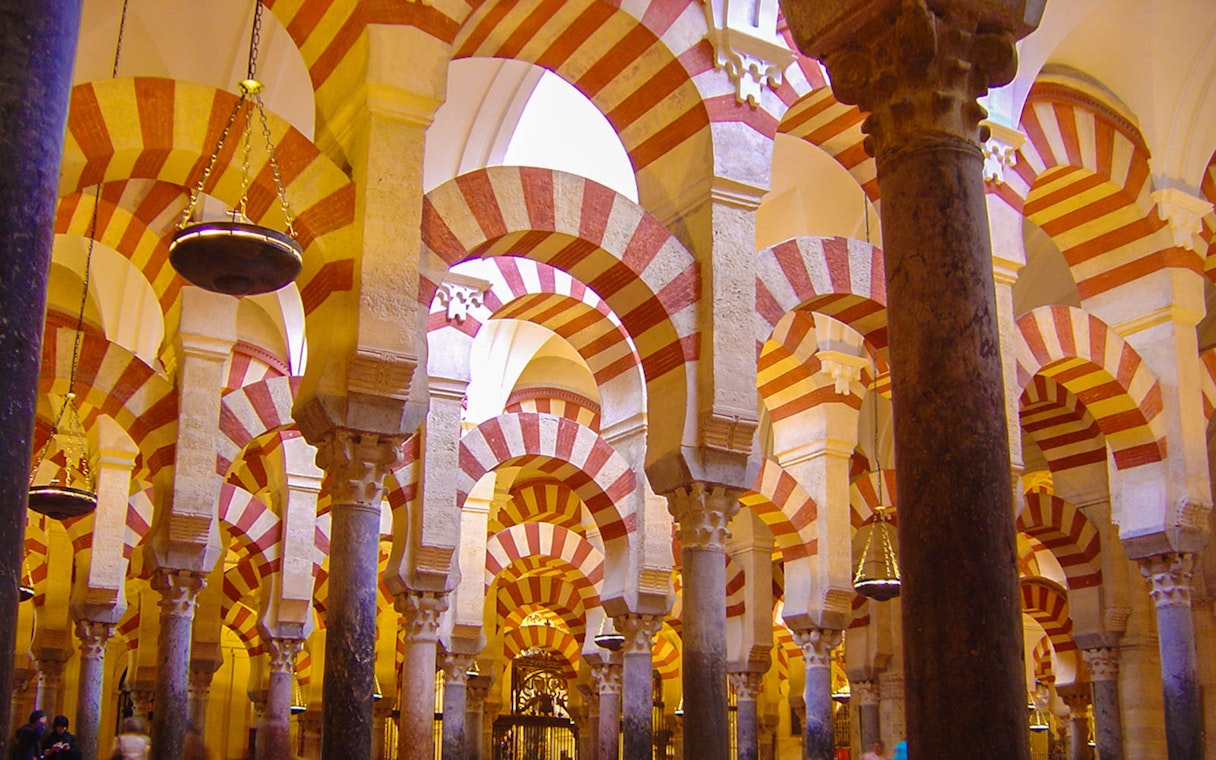 Striped arches inside the Mosque-Cathedral of Córdoba on a day trip from Granada.