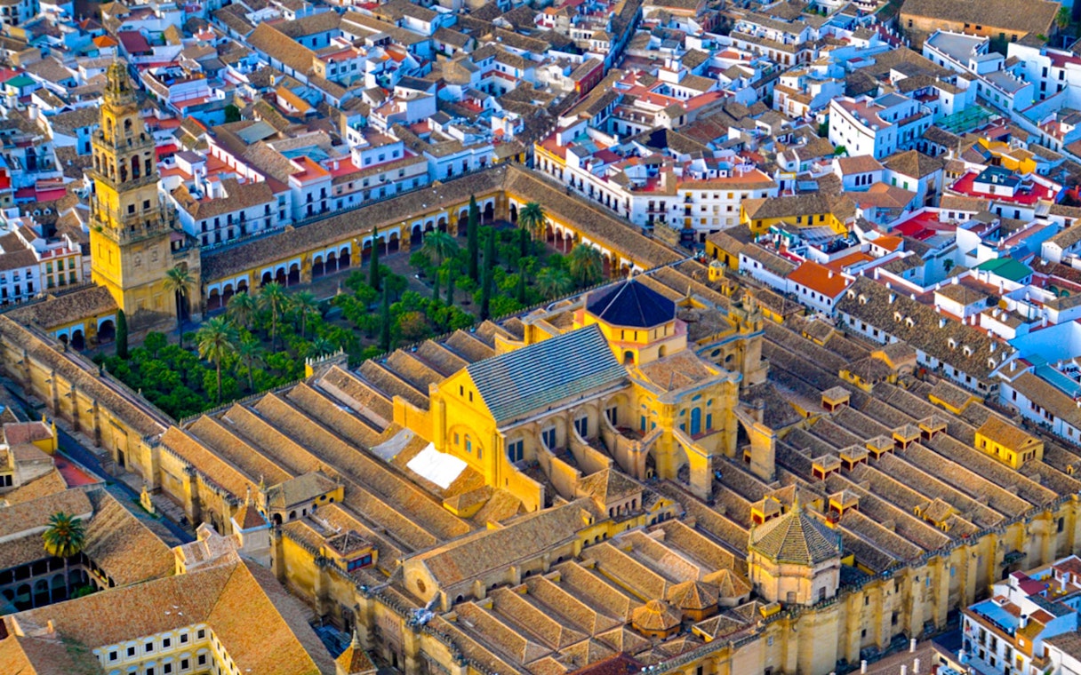Aerial view of the Mosque-Cathedral of Córdoba, Spain, surrounded by city buildings.