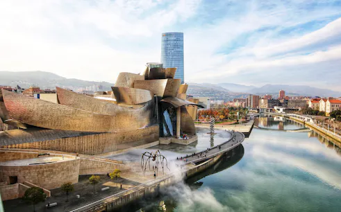 Guggenheim Museum Bilbao with modern architecture and riverside view.