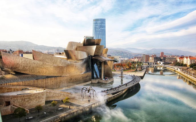 Guggenheim Museum Bilbao with modern architecture and riverside view.