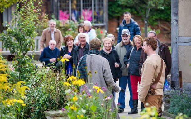 Tour group exploring gardens on Warwick Castle, Shakespeare's England, Oxford & the Cotswolds Day Tour.