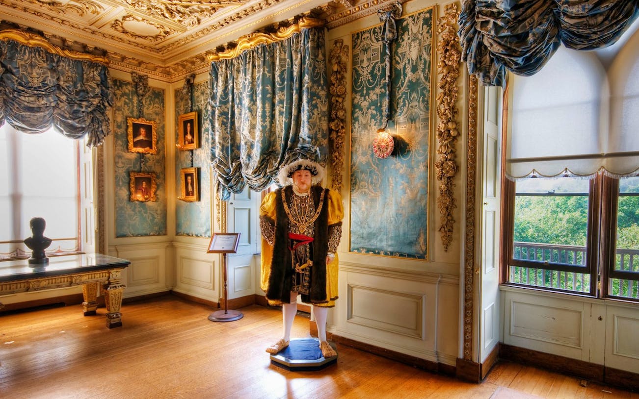 Warwick Castle interior with historical figure statue, part of Shakespeare's England tour.