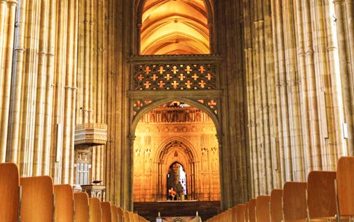 Interior view of Canterbury Cathedral's nave with ornate arches and columns.