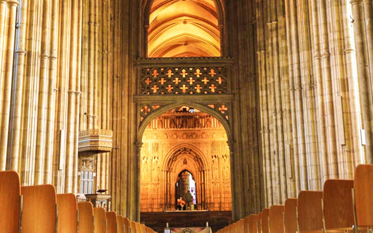 Interior view of Canterbury Cathedral's nave with ornate arches and columns.