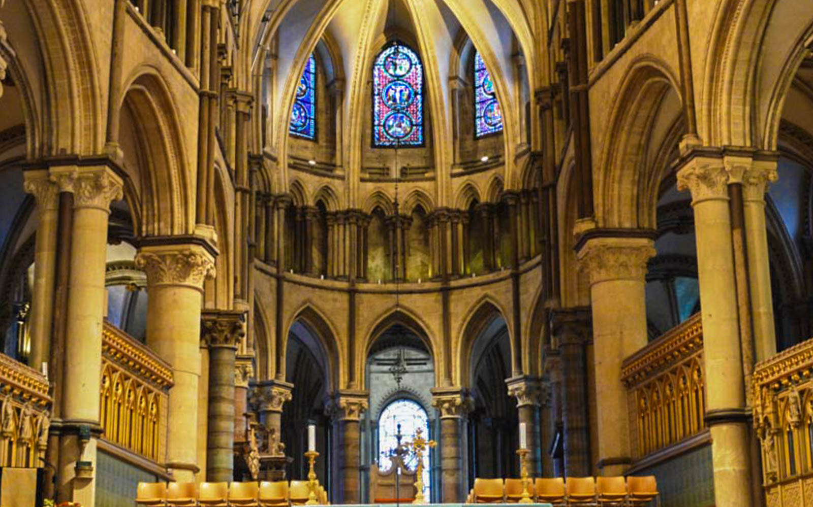 Interior of Canterbury Cathedral with stained glass windows and Gothic arches.