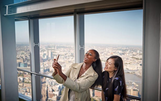 Visitors taking a selfie with a view of London from The Shard.