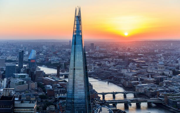 Sunset view of London skyline from The Shard, featuring the Thames River and cityscape.