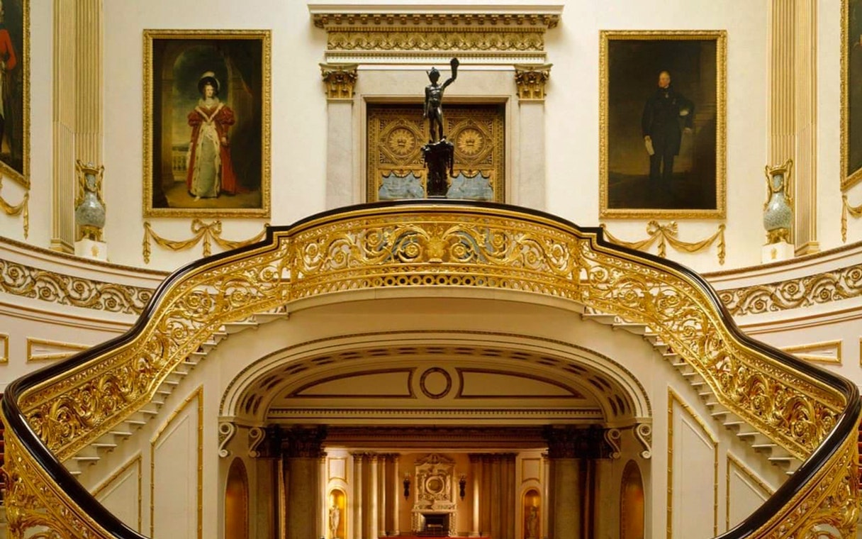 Buckingham Palace State Rooms with ornate staircase and historical portraits.