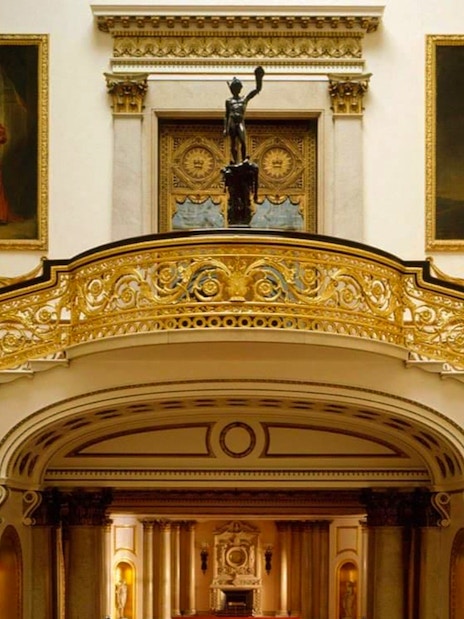 Buckingham Palace State Rooms with ornate staircase and historical portraits.