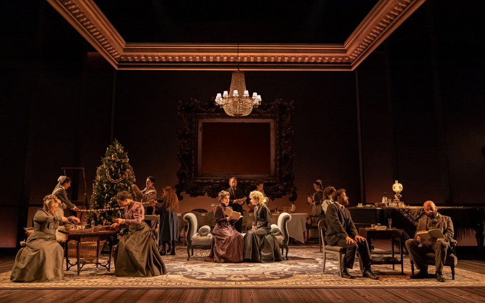 Family gathering in a Leopoldstadt living room with a Christmas tree and chandelier.