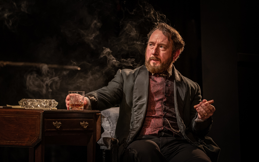 Man in period costume holding a drink and cigar, Leopoldstadt play scene.