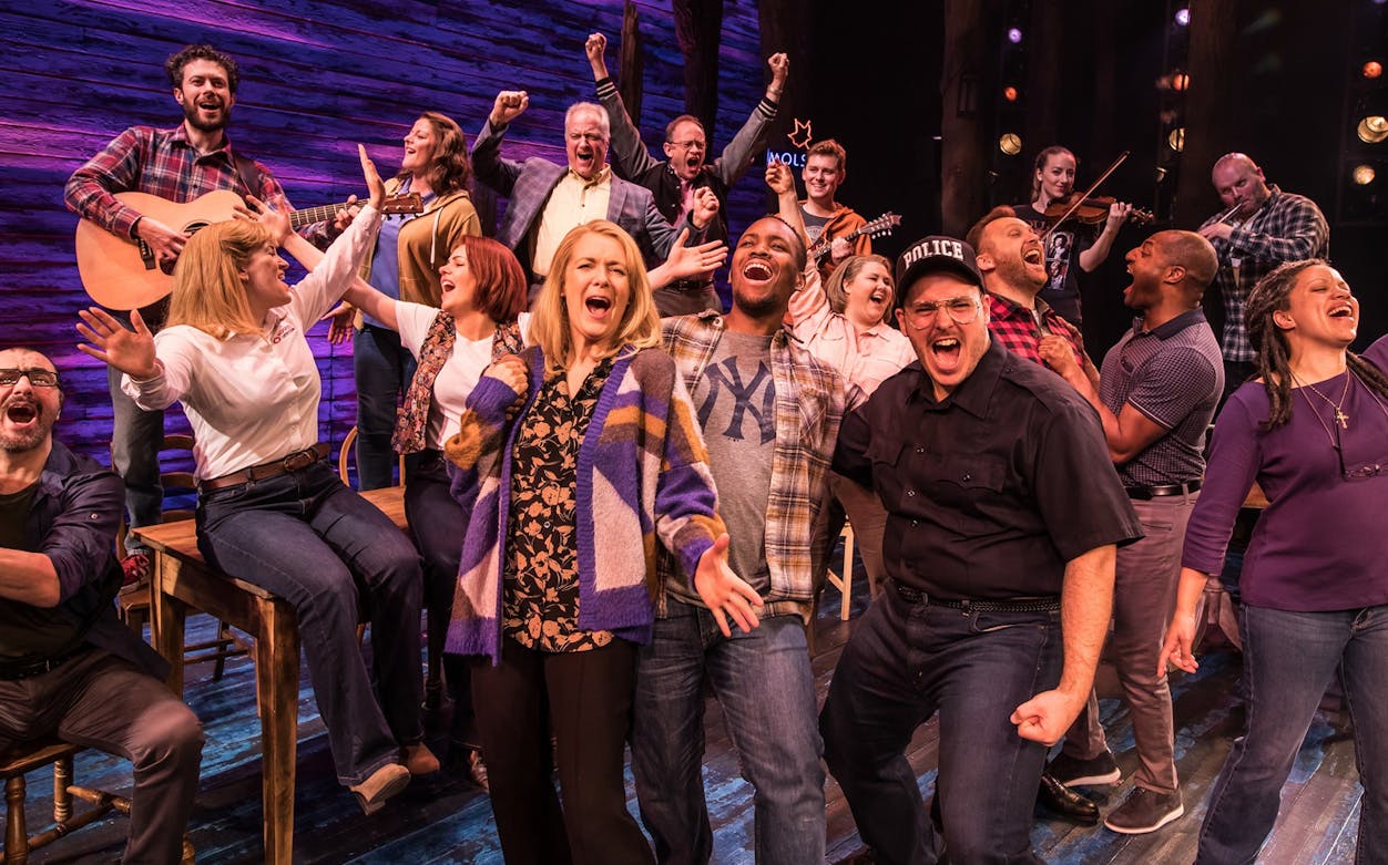 Cast of "Come From Away" performing on stage, showcasing vibrant energy and musical talent.