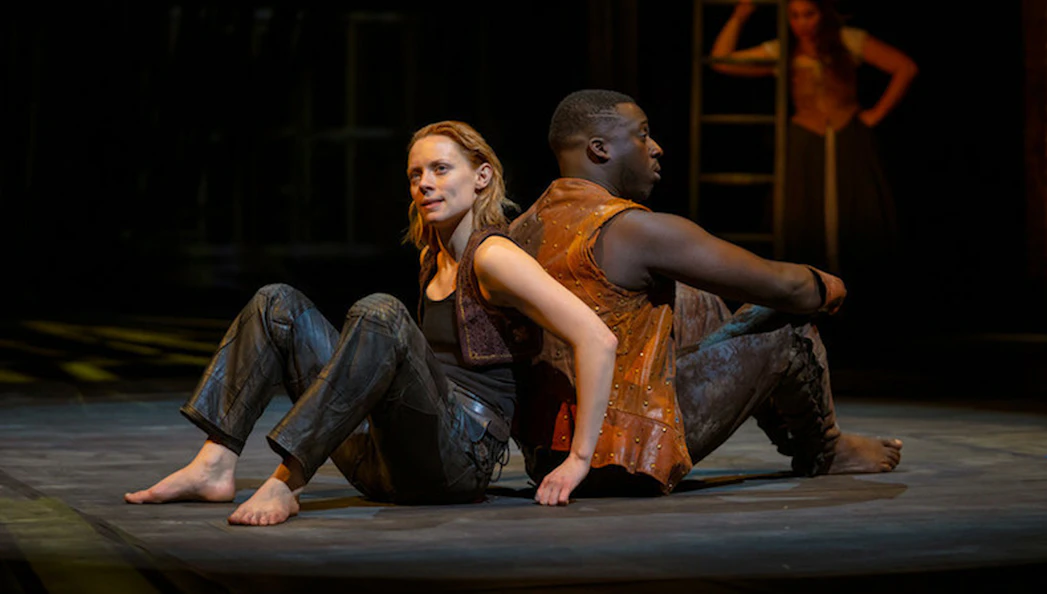 Actors performing a scene from "As You Like It" on stage.