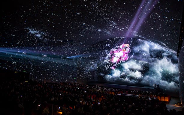 Audience watching The Last Judgement: The Sistine Chapel Immersive Show with cosmic visuals.