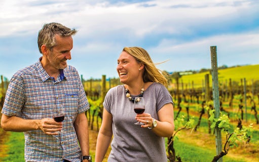 Couple enjoying wine in a vineyard during Hunter Valley Food and Wine Lovers Experience.