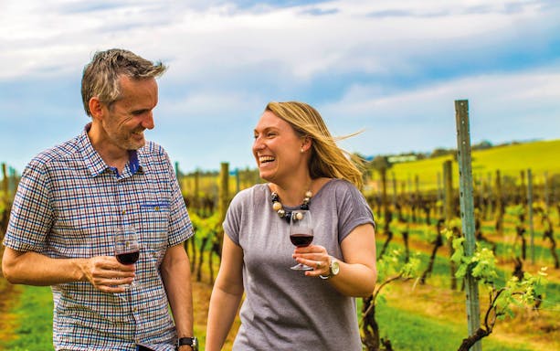 Couple enjoying wine in a vineyard during Hunter Valley Food and Wine Lovers Experience.