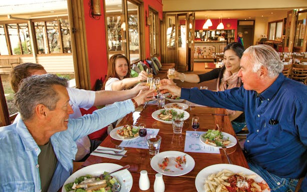 Group toasting at a dining table during Hunter Valley Food and Wine Lovers Experience.