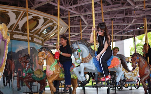 Visitors enjoying a carousel ride at Siam Park City, Bangkok.
