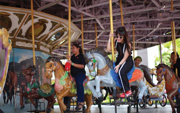 Visitors enjoying a carousel ride at Siam Park City, Bangkok.