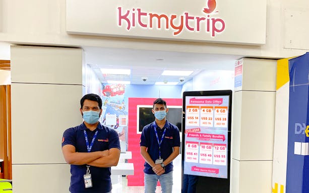 4G SIM card pickup counter at DXB Airport, Dubai, with staff and data offers displayed.