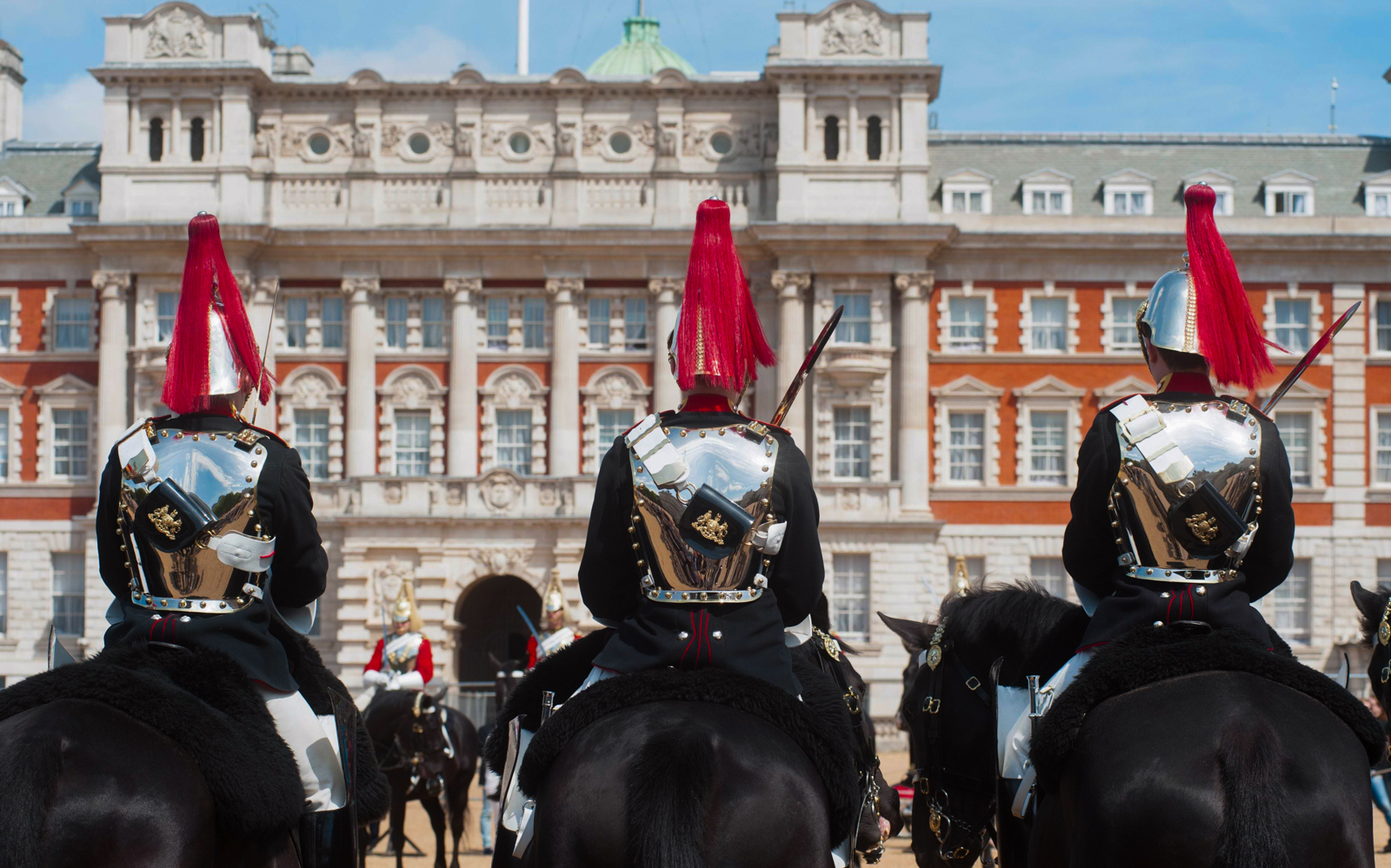 Guards on horseback in ceremonial attire outside Buckingham Palace, London.