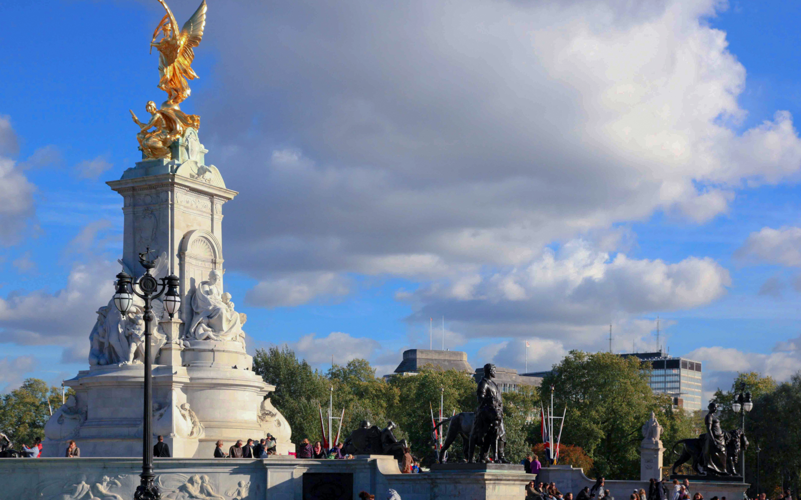 Victoria Memorial near Buckingham Palace, London, with tourists gathered around.