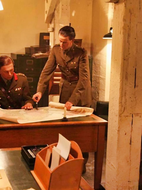 Two men in military uniforms examining a map in Churchill’s War Rooms, London.
