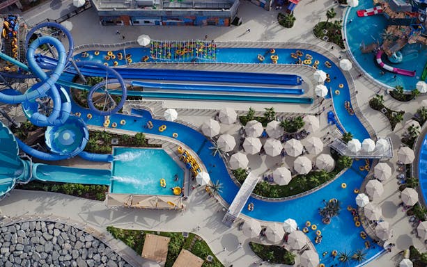 Aerial view of Laguna Waterpark with slides, pools, and sun umbrellas in Dubai.