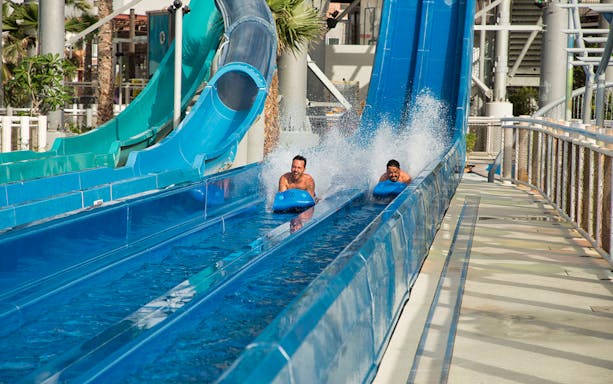 Two people racing down water slides at Laguna Waterpark.