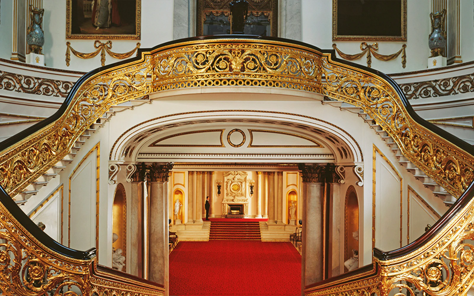 Buckingham Palace State Rooms grand staircase with ornate gold detailing.