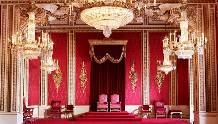 Buckingham Palace State Rooms with ornate chandeliers and red decor.