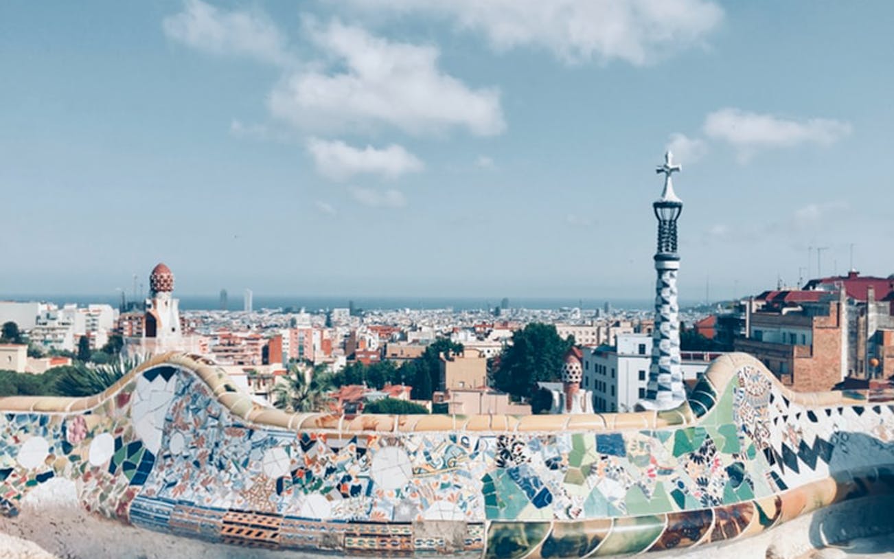 Park Guell mosaic terrace overlooking Barcelona skyline, Spain.