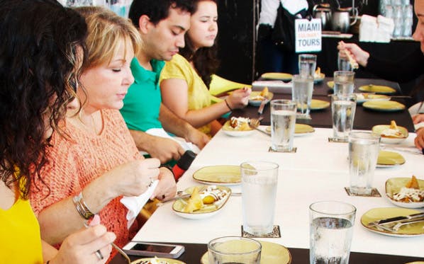 Group enjoying food tasting on Wynwood Food & Art Tour in Miami.
